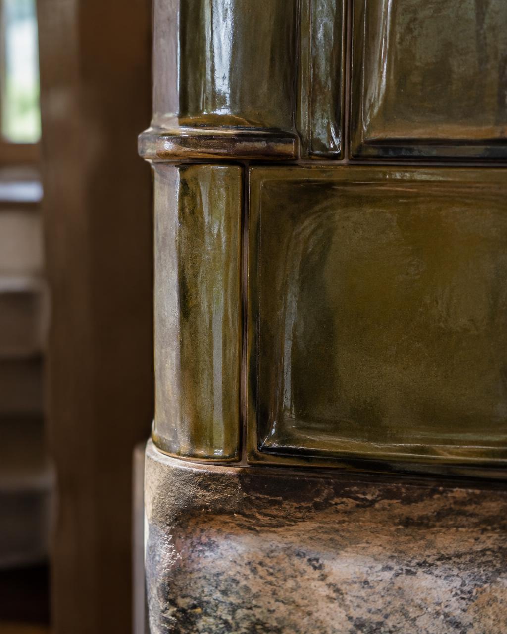 Detail glasierter Ofenkacheln auf Naturstein